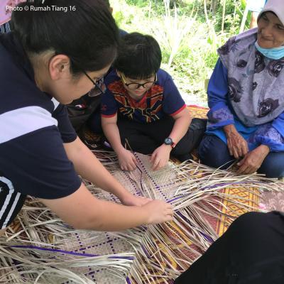 Learning how to weave a mengkuang mat.